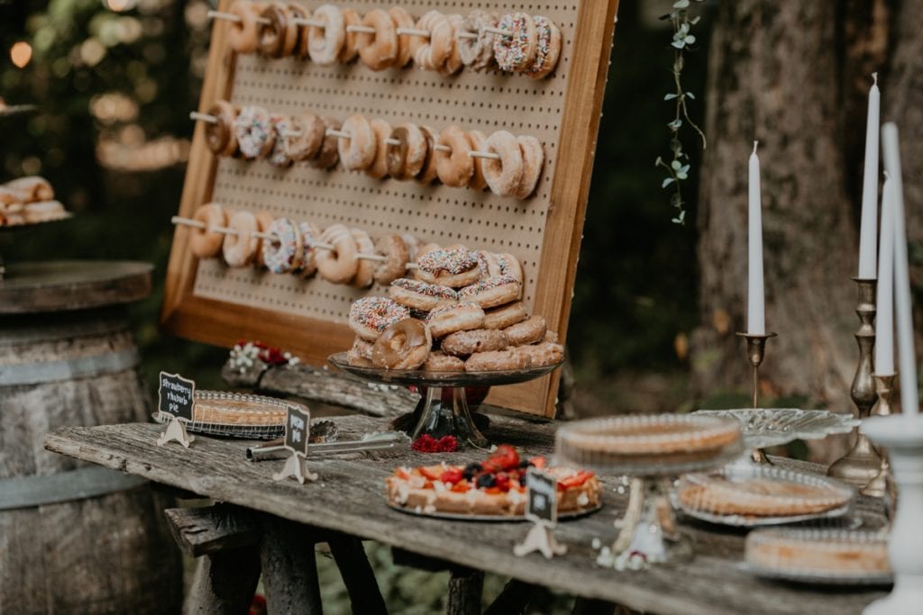 Wedding desert bar at The Clearing in Shedden, ON. Rustic and boho inspired with a donut pegboard wall.