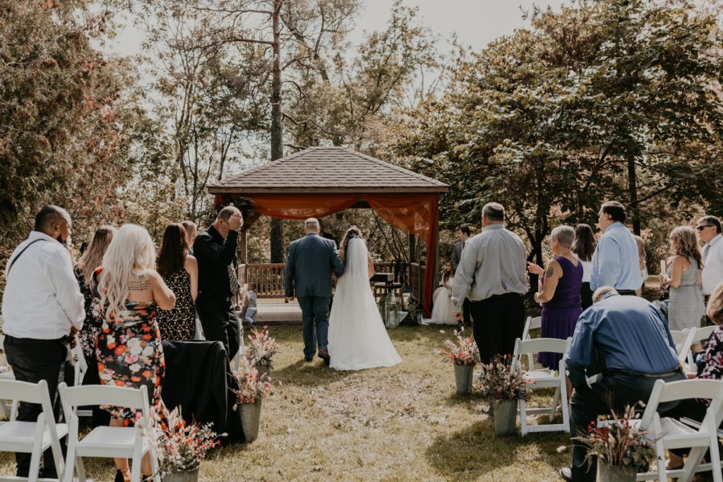 Bride's father walks her down the aisle for their outdoor wedding reception on the grounds of the Elsie Perrin Williams Estate in London, ON.