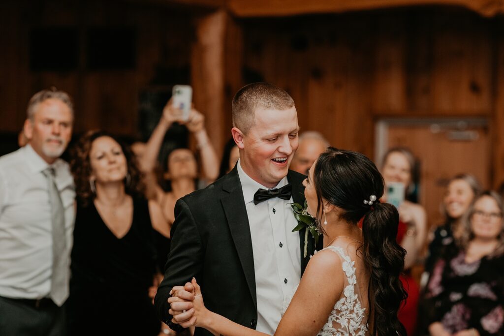 Bride and groom share first dance at their holland marsh wineries wedding. they are laughing and looking into each other's eyes.