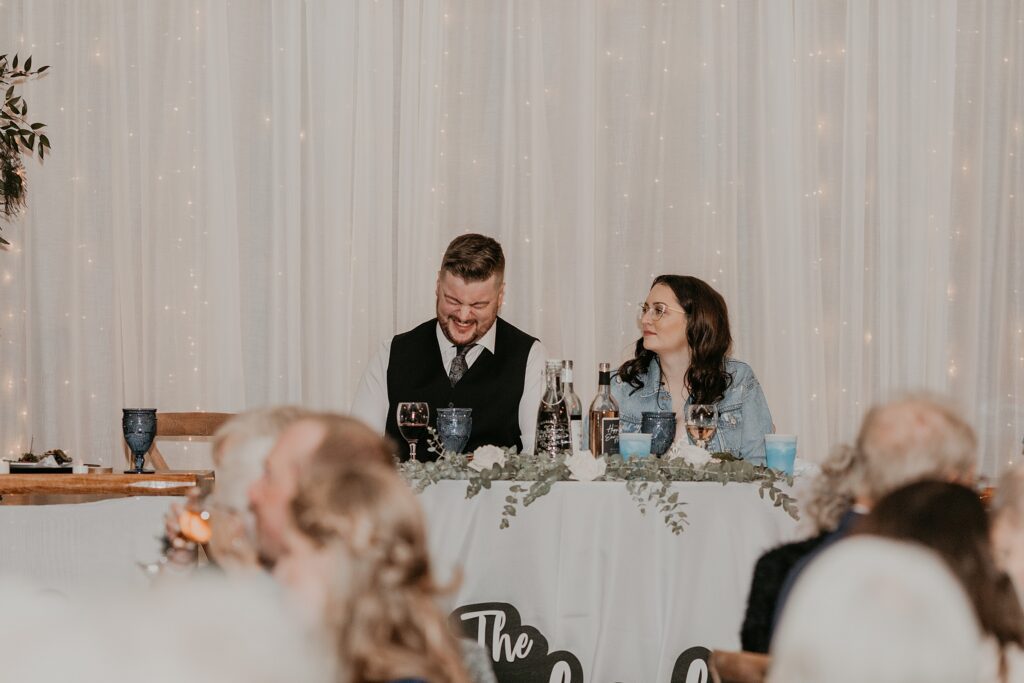 Bride and groom laugh during wedding speeches at their Crescent Hill Acres wedding. Captured by top Sarnia wedding photographer Ashlee Ellison.